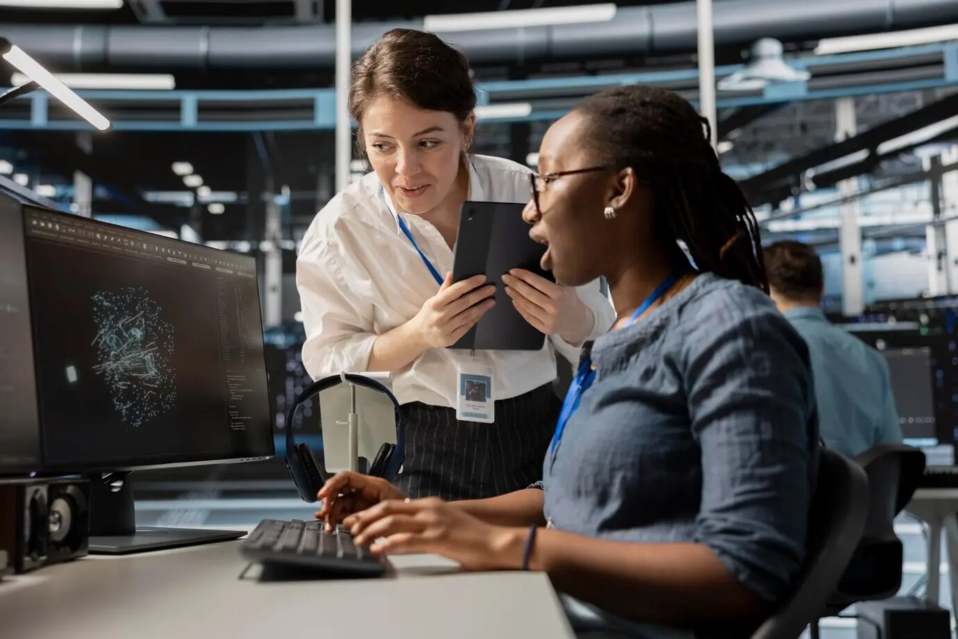 Техники дата-центра смотрят на визуализацию на экране ПК.