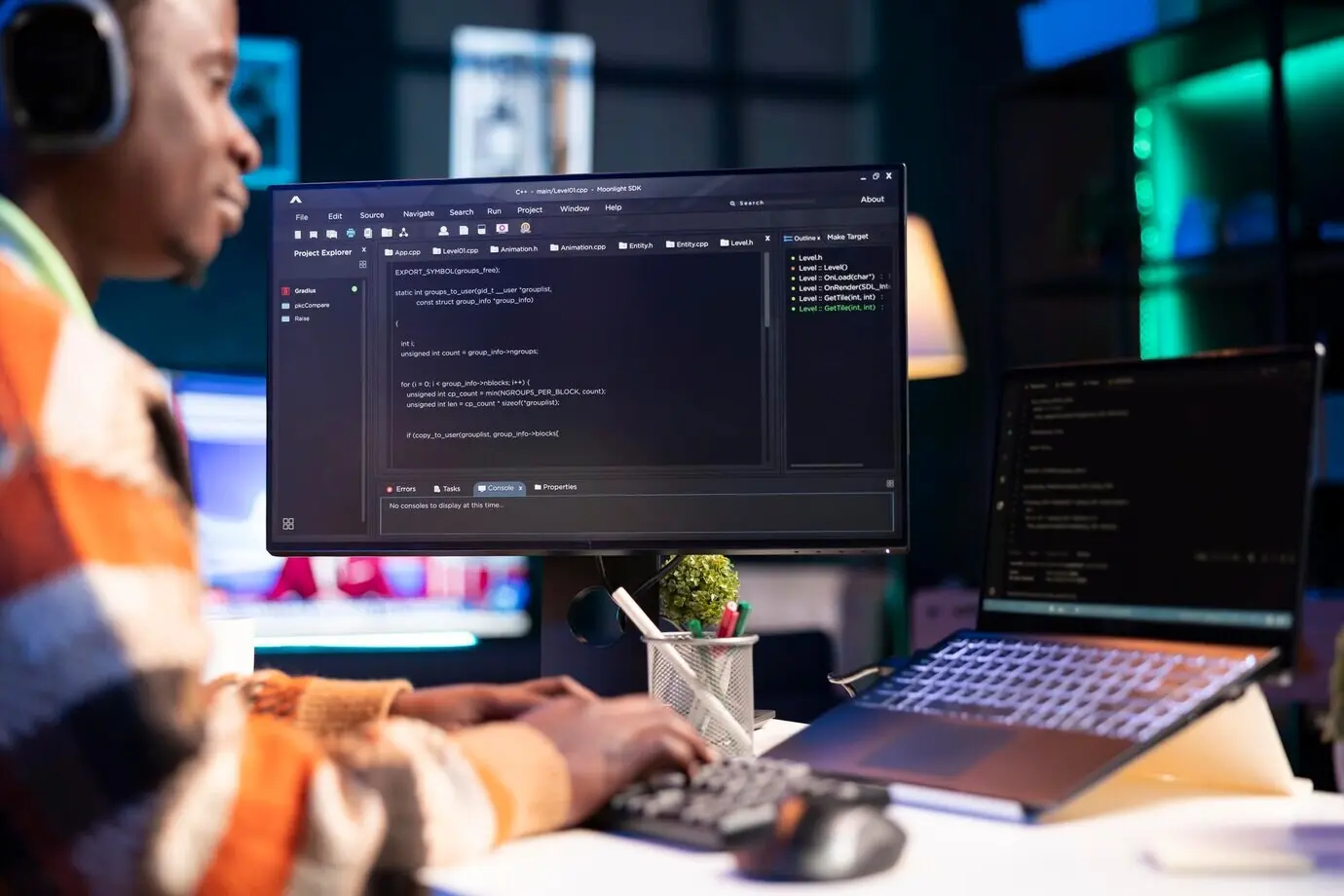 Афроамериканский учёный‑информатик пишет код на ПК в домашнем офисе.